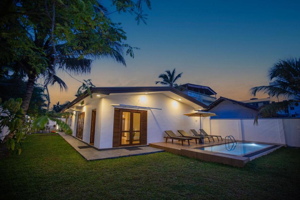 a house with a patio and a swimming pool at night at Villa D8 in Mirissa