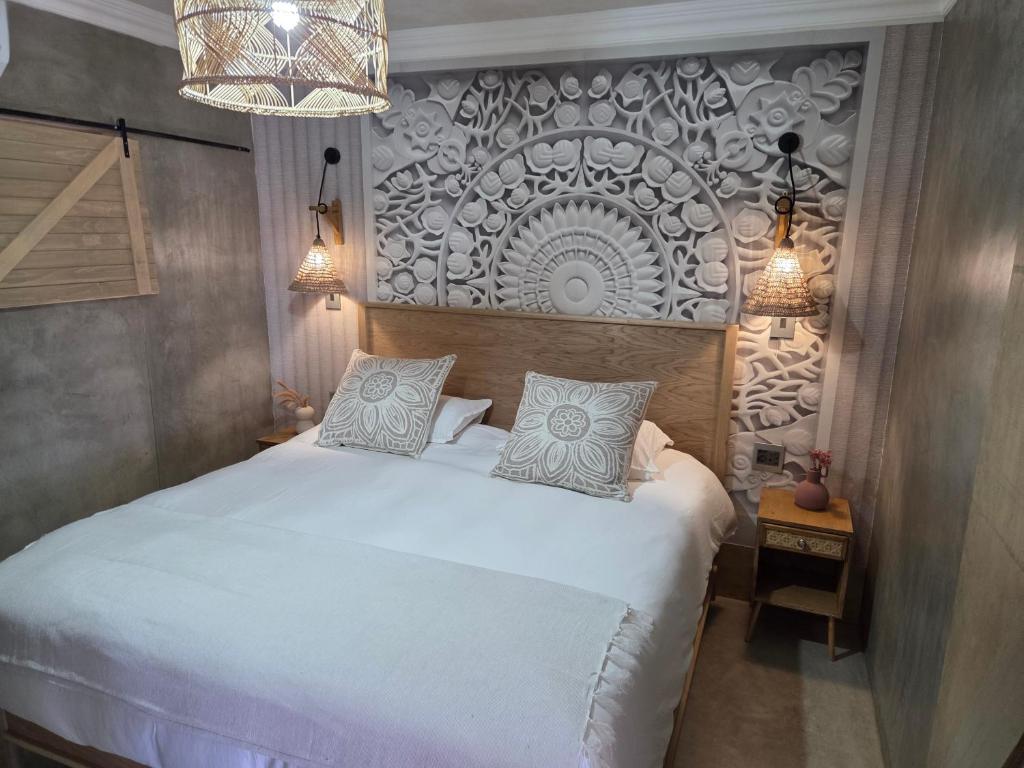 a bedroom with a white bed and a chandelier at Luvlé Lux Apartments in Eros Airport