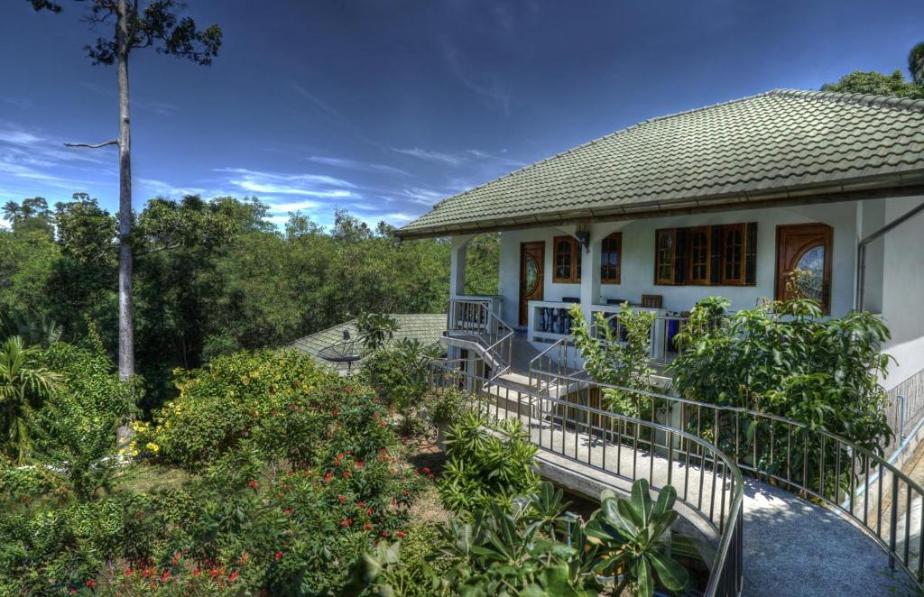 a white house with a porch and a garden at Gila's Garden in Lamai