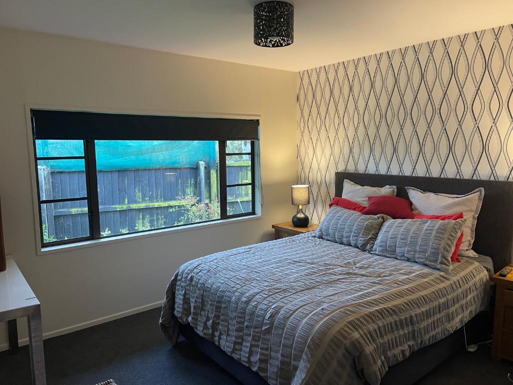 a bedroom with a bed and a large window at Kaiapoi Village Deluxe Room with En-Suite Bathroom in Kaiapoi