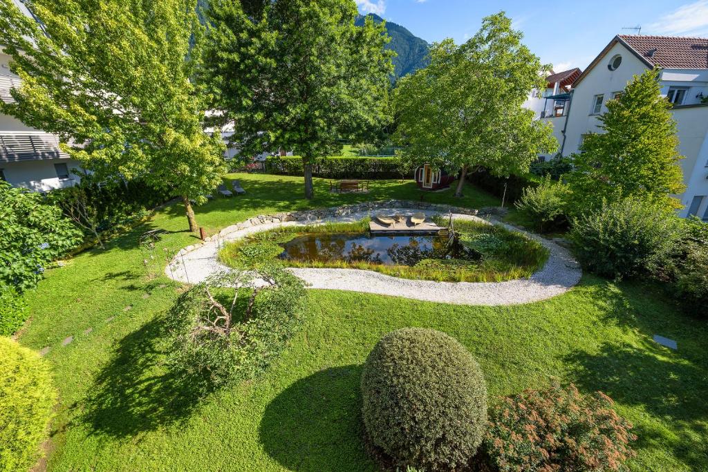 einen Blick über einen Garten mit einem Teich in der Unterkunft Garni Hotel Kessler in Dorf Tirol