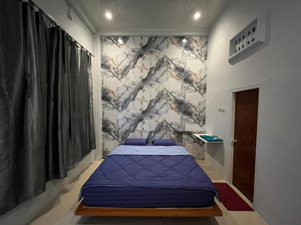 een slaapkamer met een paars bed en een muur bij Gedung Putih Syariah in Palas 2