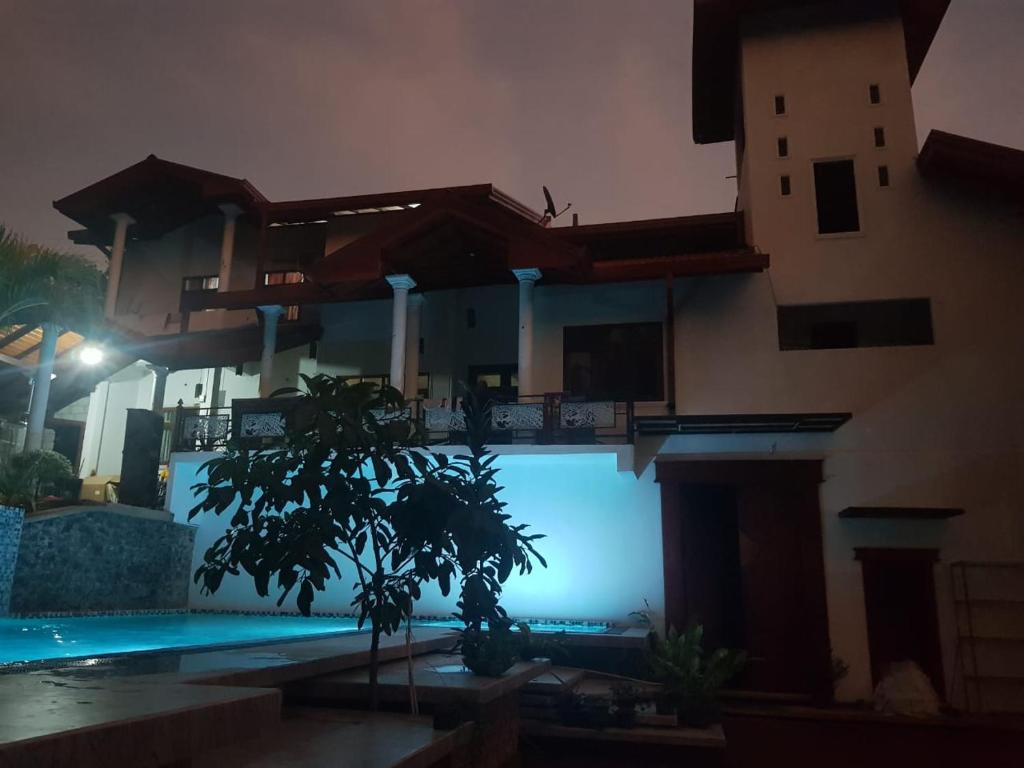 een huis met een boom voor een zwembad bij Floating Castle Villa in Avissawella