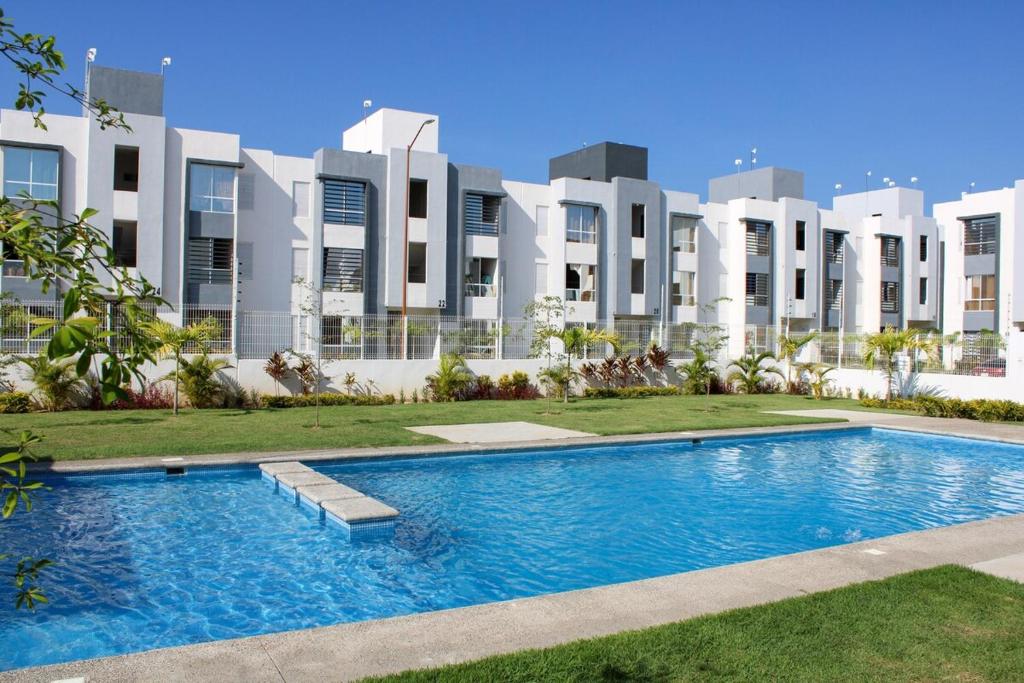 a swimming pool in front of a building at Blue Sea Vallarta - Relax, Explore and Enjoy! in Los Algodones