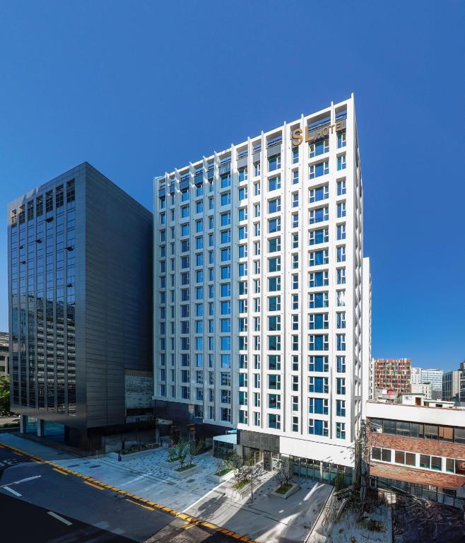 a tall white building with a lot of windows at SL Hotel Myeongdong in Seoul