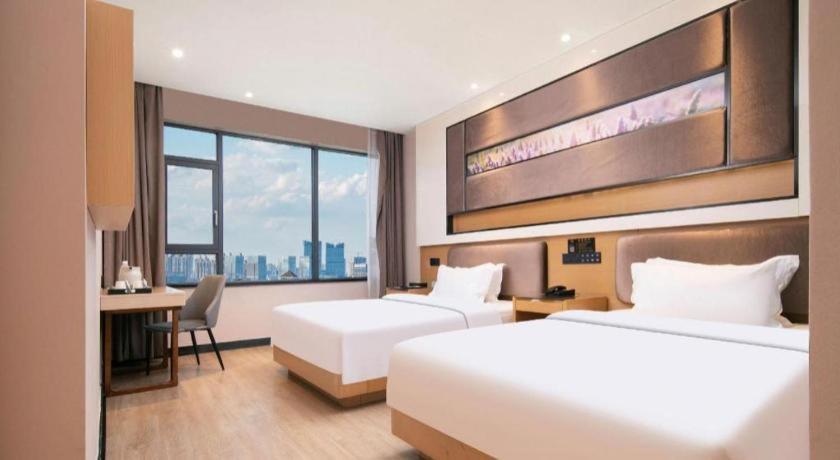 Ένα ή περισσότερα κρεβάτια σε δωμάτιο στο Lavande Hotel Wuhan Huanghelou Branch