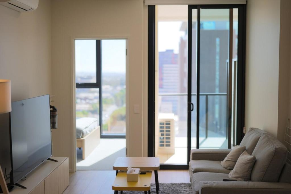 Una sala de estar con un sofá y un televisor de pantalla plana. en The Sirius in the central of CBD, en Adelaida