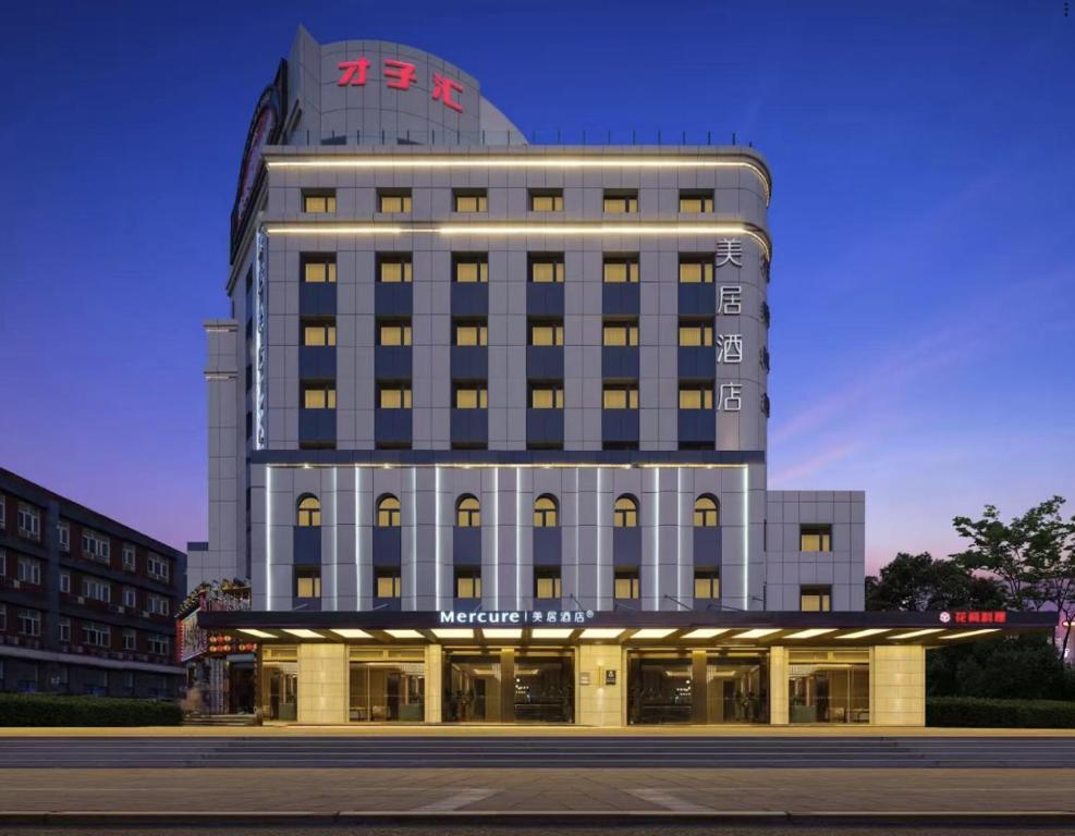 a large building with a sign on top of it at Mercure Beijing Anzhen Olympic Center in Beijing