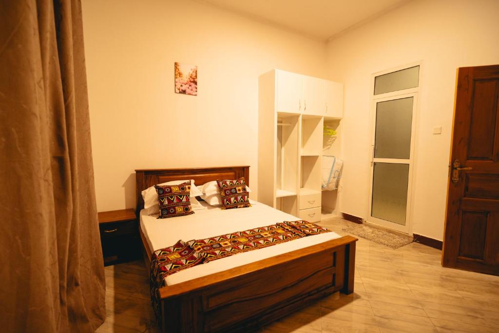 een slaapkamer met een bed in een kamer bij FREEDOM homes in Arusha