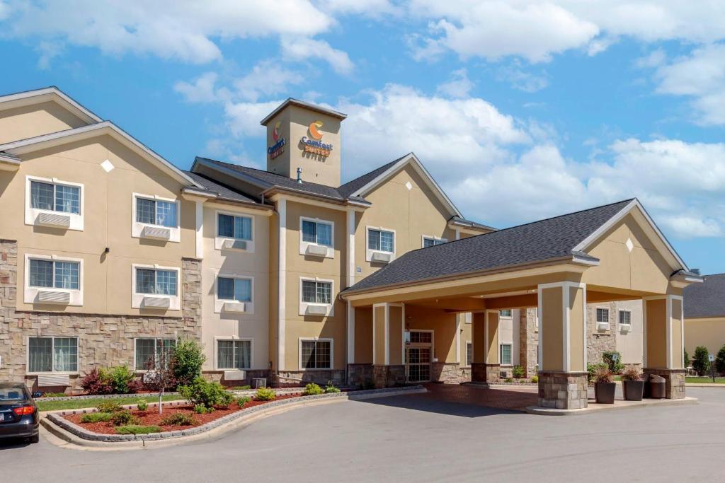 een weergave van de voorkant van een hotel met een parkeerplaats bij Comfort Suites Johnson Creek Conference Center in Johnson Creek