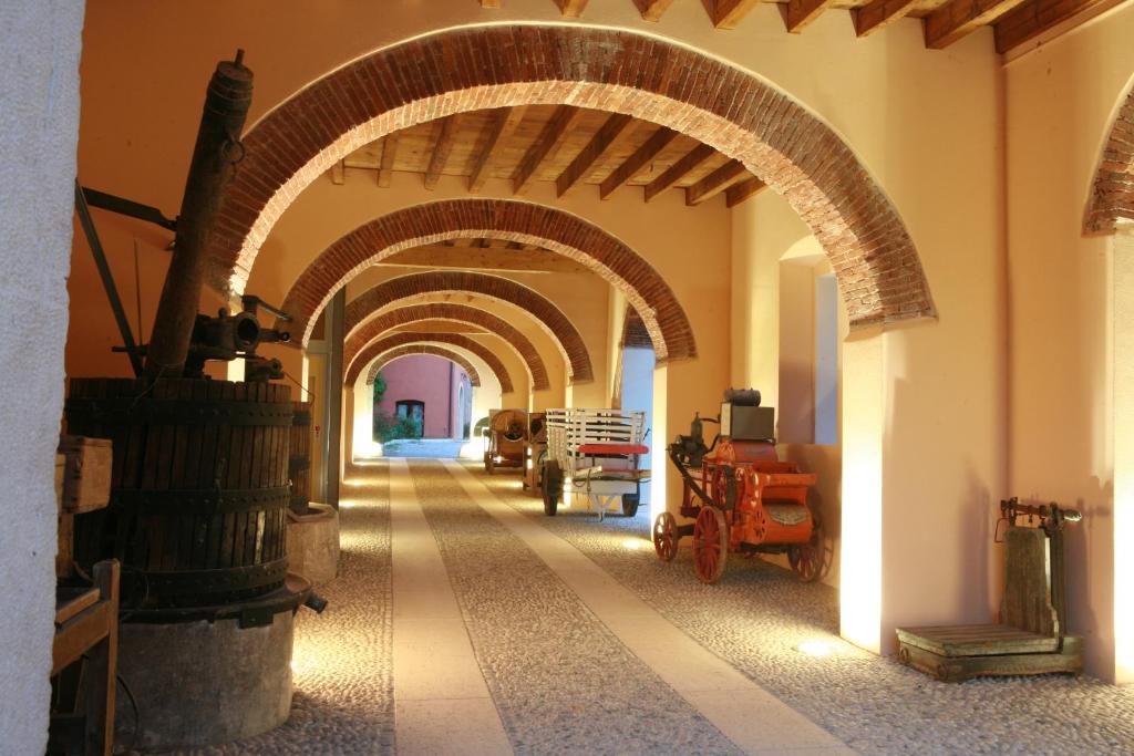 un pasillo con arcos en un edificio con caballos en Agriturismo La Filanda, en Manerba del Garda