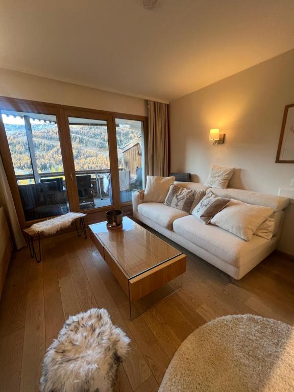 een woonkamer met een witte bank en een tafel bij 5 personnes, 2Pieces exceptionnel havre de détente et de confort, immense terrasse, vue incroyable, Tout pédestre, à 10m du funiculaire, parking in Isola 2000