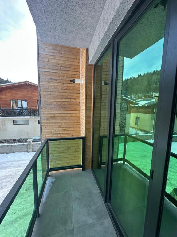 a room with glass doors and a balcony at Snow Forest ԲԱԿՈՒՐԻԱՆԻ-ბაკურიანი-BAKURIANI in Bakuriani