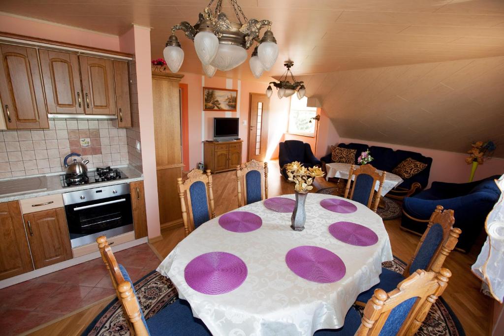 een keuken en eetkamer met een tafel met paarse borden erop bij Agroturystyka nad Jeziorem Gaładuś in Dusznica