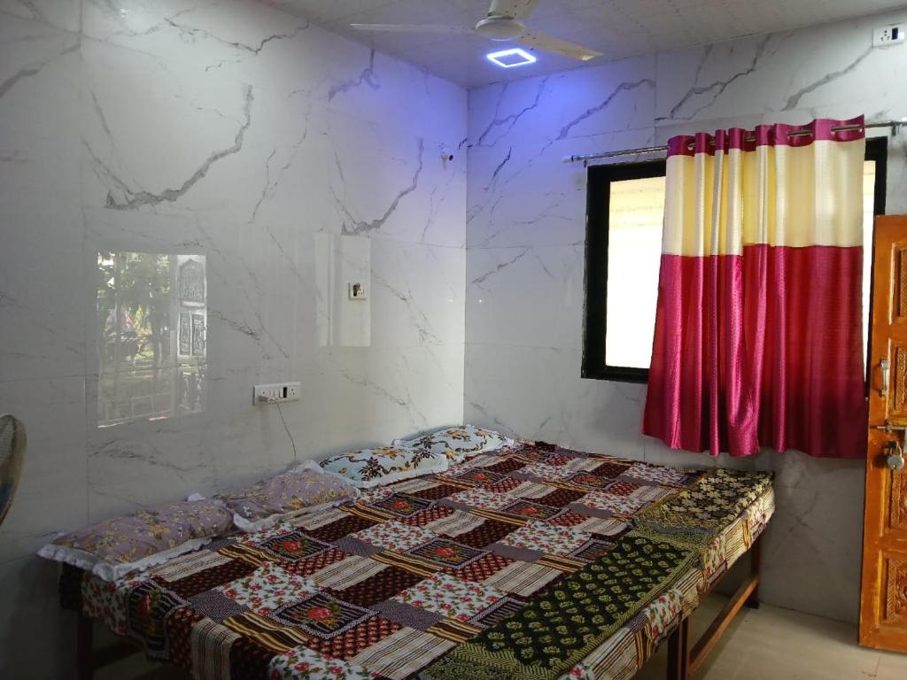 a bedroom with a bed with a quilt on it at Sahil Bed and Breakfast in Alibag