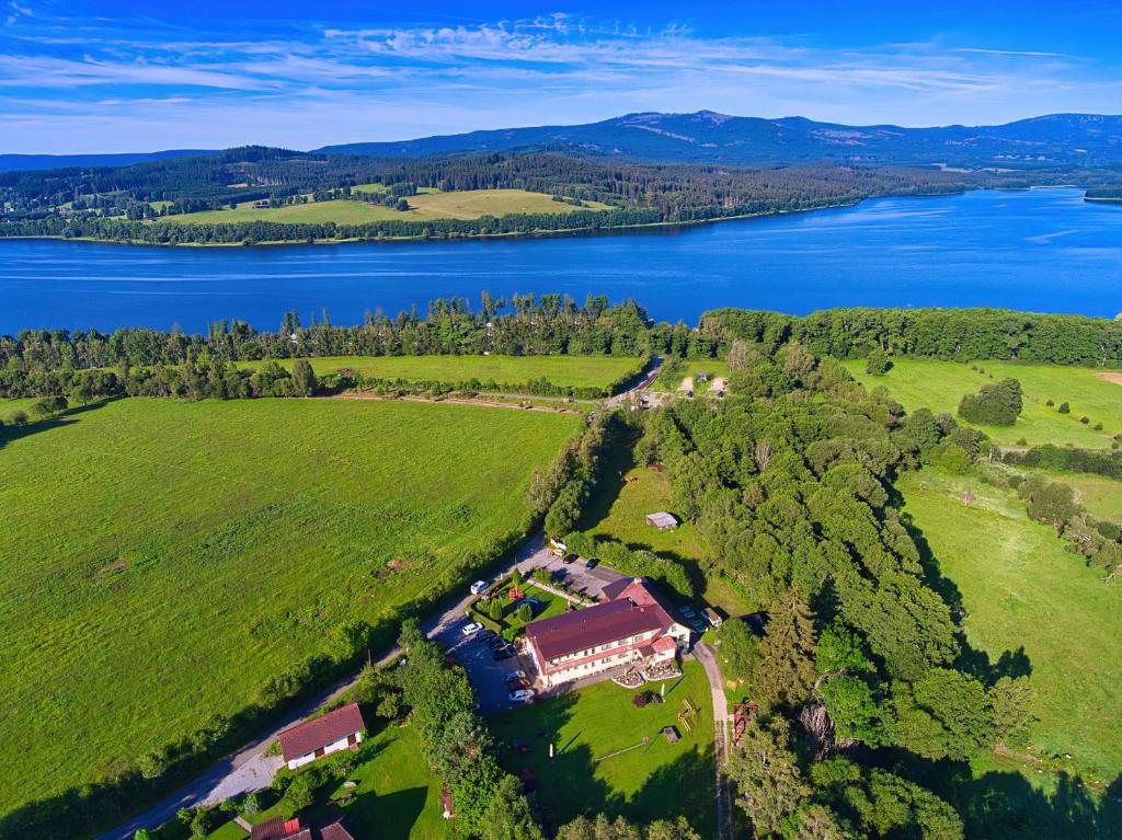 een luchtzicht op een huis in een veld naast een meer bij Penzion u Kukačků in Horní Planá