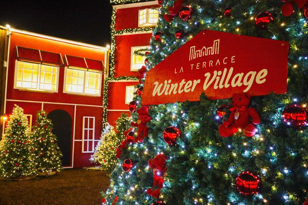 a christmas tree with a sign on it in front of a house at Yeosu Calacatta Hotel & Resort in Yeosu
