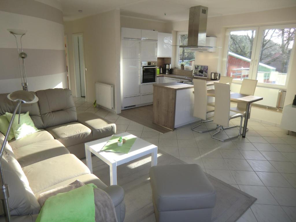 a living room with a couch and a kitchen at Ferienwohnung Marquardt mit Wallbox in Boltenhagen