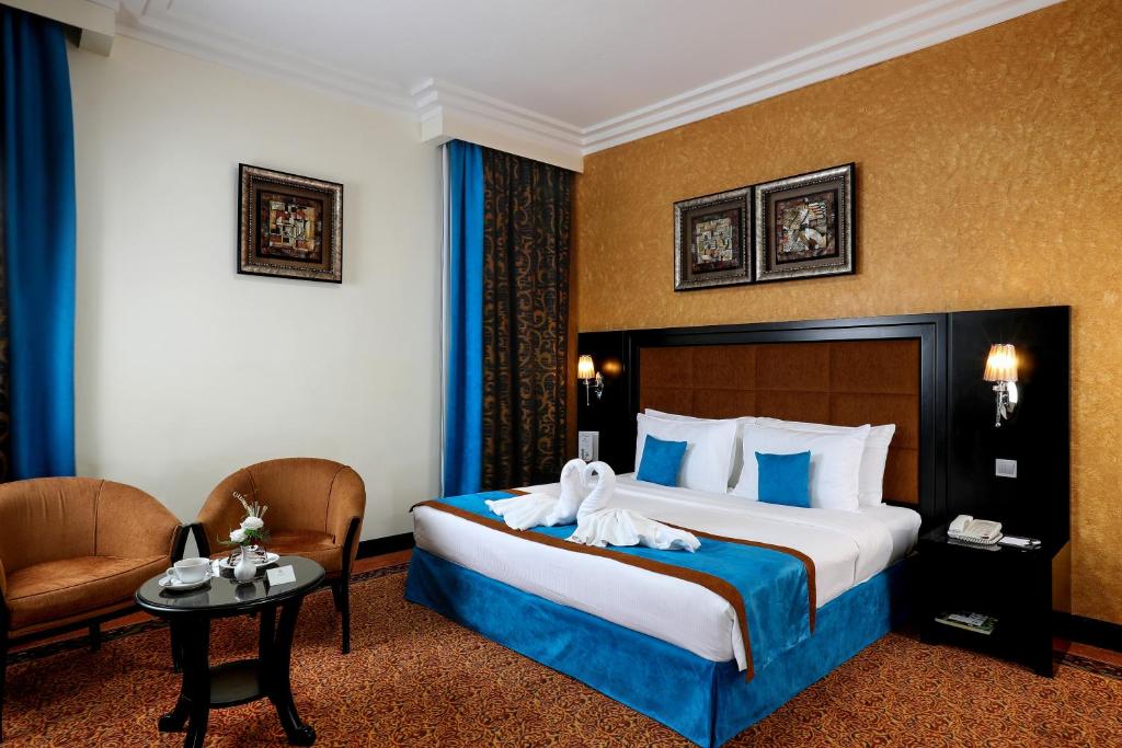 een hotelkamer met een bed met handdoeken erop bij Royal Grand Suite Hotel in Sharjah