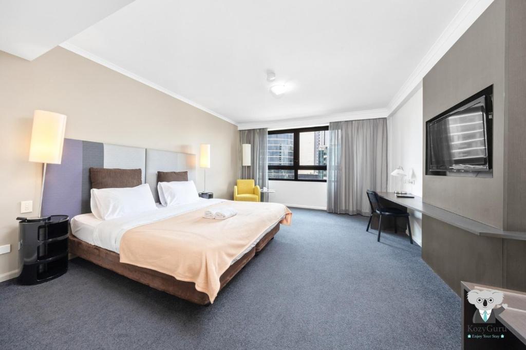 KozyGuru | Parramatta Studio Steps to Shops, Cafés في سيدني: غرفة فندقية بها سرير كبير ومكتب