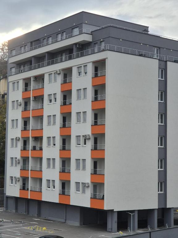 a white apartment building with orange at Hari Apartmani Oaza in Tuzla