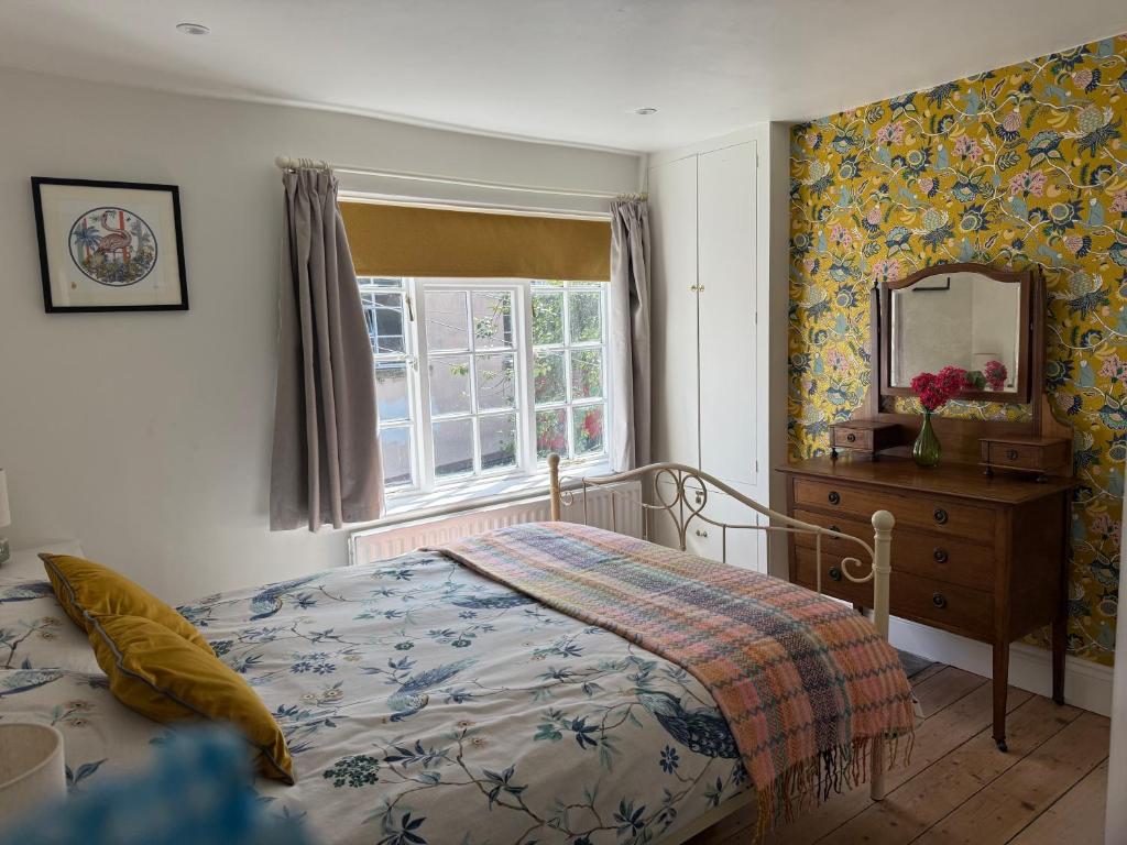 a bedroom with a bed and a dresser and a mirror at North Laine Sunny Cottage - PARKING available in Brighton & Hove
