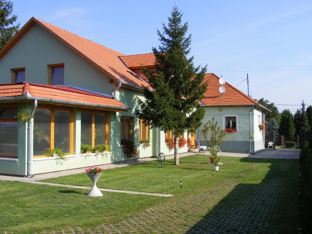 una casa con un árbol en el patio en Tünde Vendégház, en Bernecebaráti