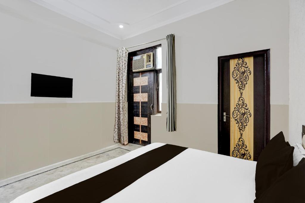 ein Schlafzimmer mit einem Bett und einem Fenster in der Unterkunft Hotel O N Nature Green in Noida