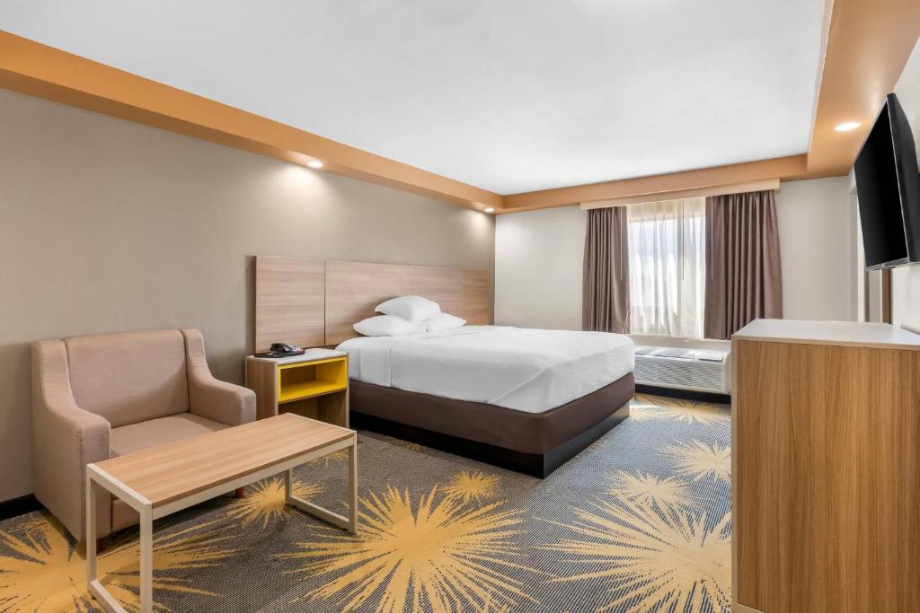 una habitación de hotel con una cama y una silla en Econo Lodge Woodbridge, en Iselin