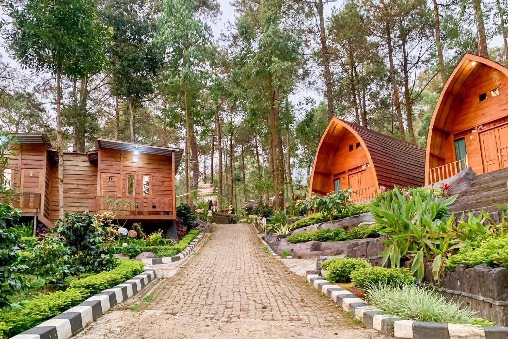 a house in the woods with a dirt road at Embun Lawu Cottage Tawangmangu in Sarangan