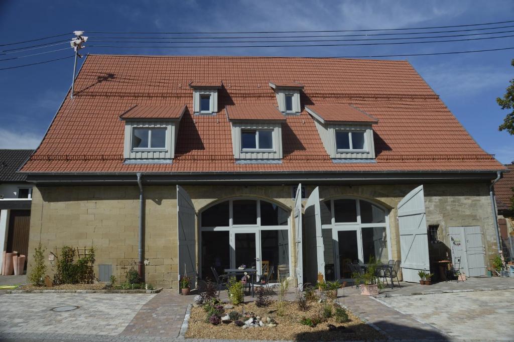 ein Haus mit rotem Kacheldach in der Unterkunft Carles Scheunenhof in Zweiflingen