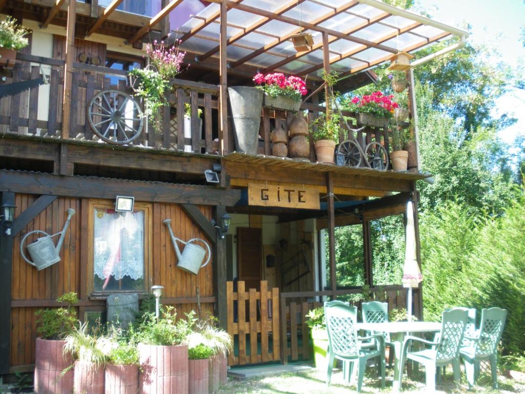 una casa con una mesa y sillas frente a ella en Le Nid Du Caveau, en Ferrette