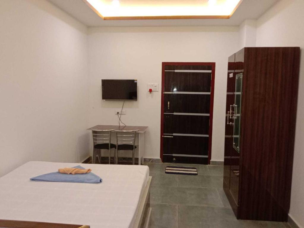 a room with a bed and a table and a television at SPOT ON Khushi Lodge in Kurua