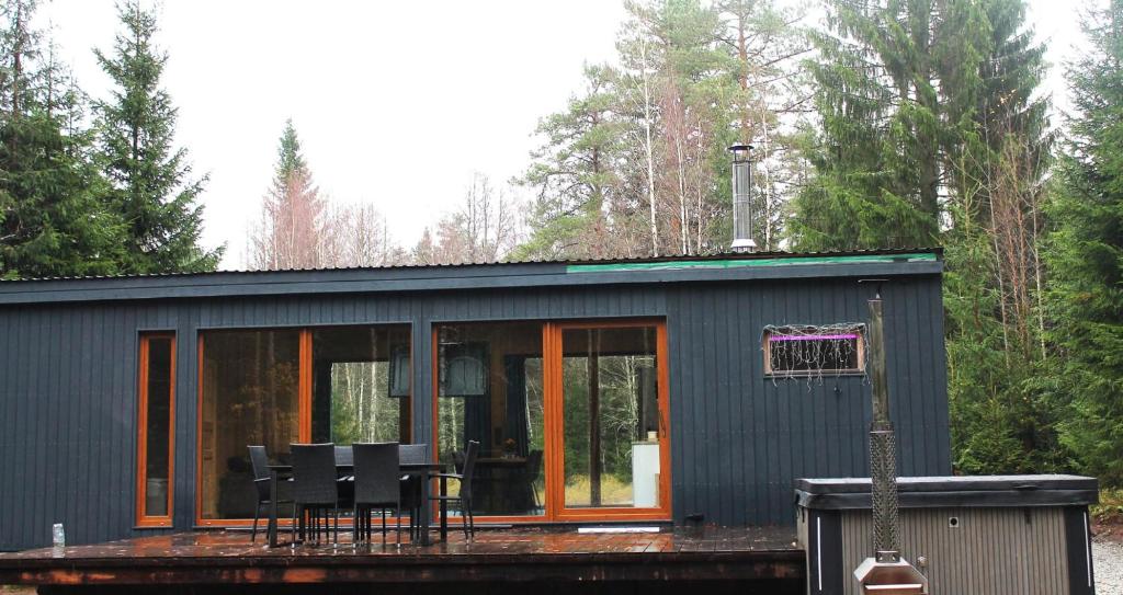 uma pequena casa com cadeiras e uma cesta de basquete em Metsamajake Hubert sauna ja mullivanniga 