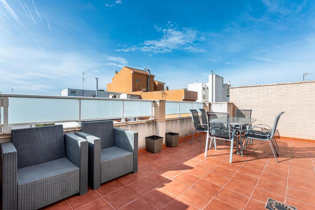 a balcony with chairs and a table on a roof at Viviaro Llibertat in Puerto de Sagunto
