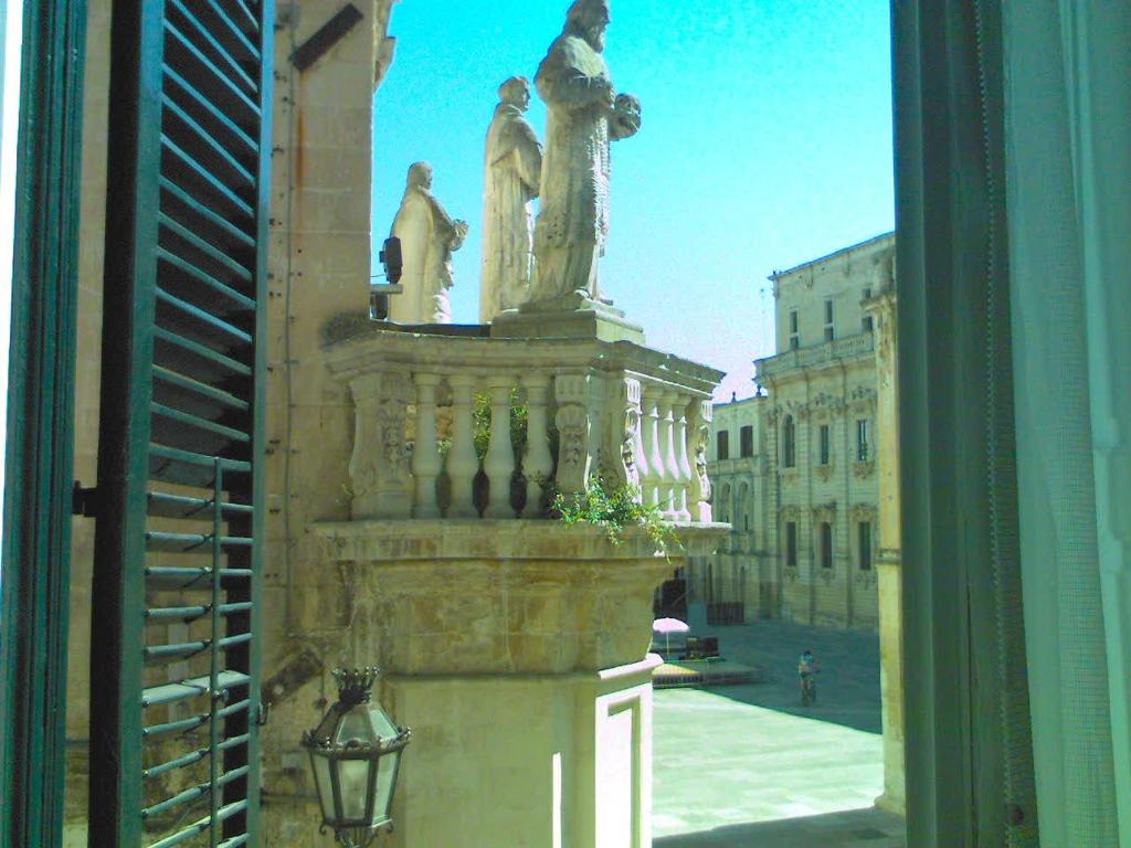 een standbeeld van twee vrouwen aan de zijkant van een gebouw bij I Balconi sul Duomo in Lecce