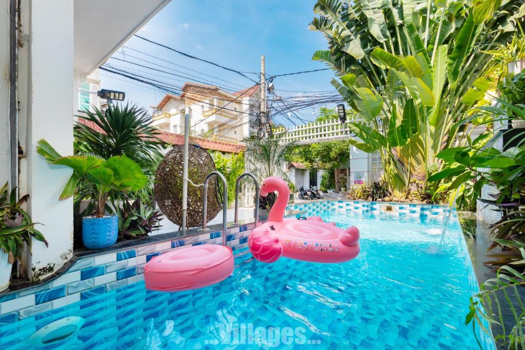Una piscina con un cisne rosa en una casa. en Villa Bãi Sau Vũng Tàu Free SUB - Xe Máy, en Vung Tau
