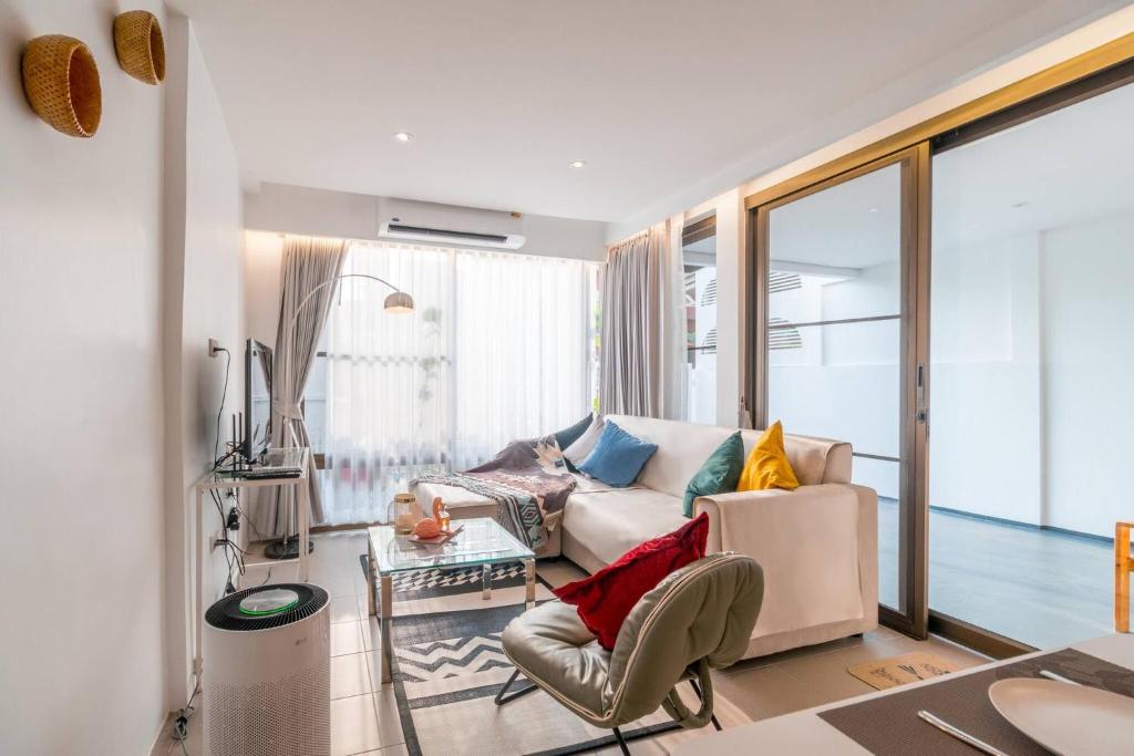 un salon avec un canapé et une table dans l'établissement Minimal House Maximum Happiness, à Thung Maha Mek