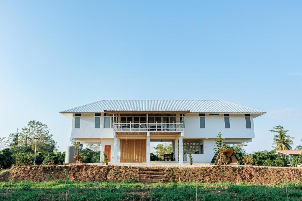 a house with a metal roof on a hill at บ้านเลม่อนริเวอร์ไซด์ in Nan