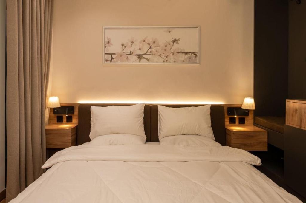 a bedroom with a large white bed with two pillows at شقة فندقية جميلة و مخصصة للايجار لشخصين في بوشر - مسقط - القرم in Jāl