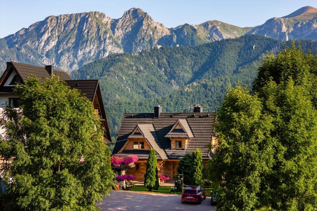 a house in the mountains with mountains in the background at Willa Turnia in Kościelisko