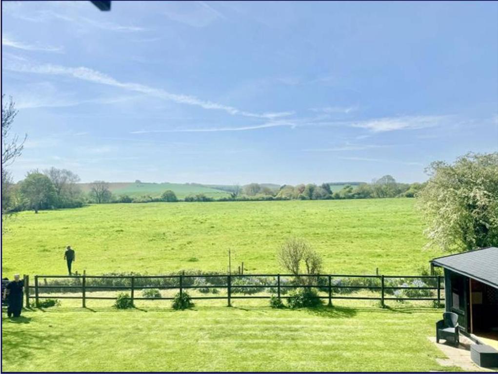 FotherbyにあるThe Old Charming Houseの柵の隣の畑に立っている男性