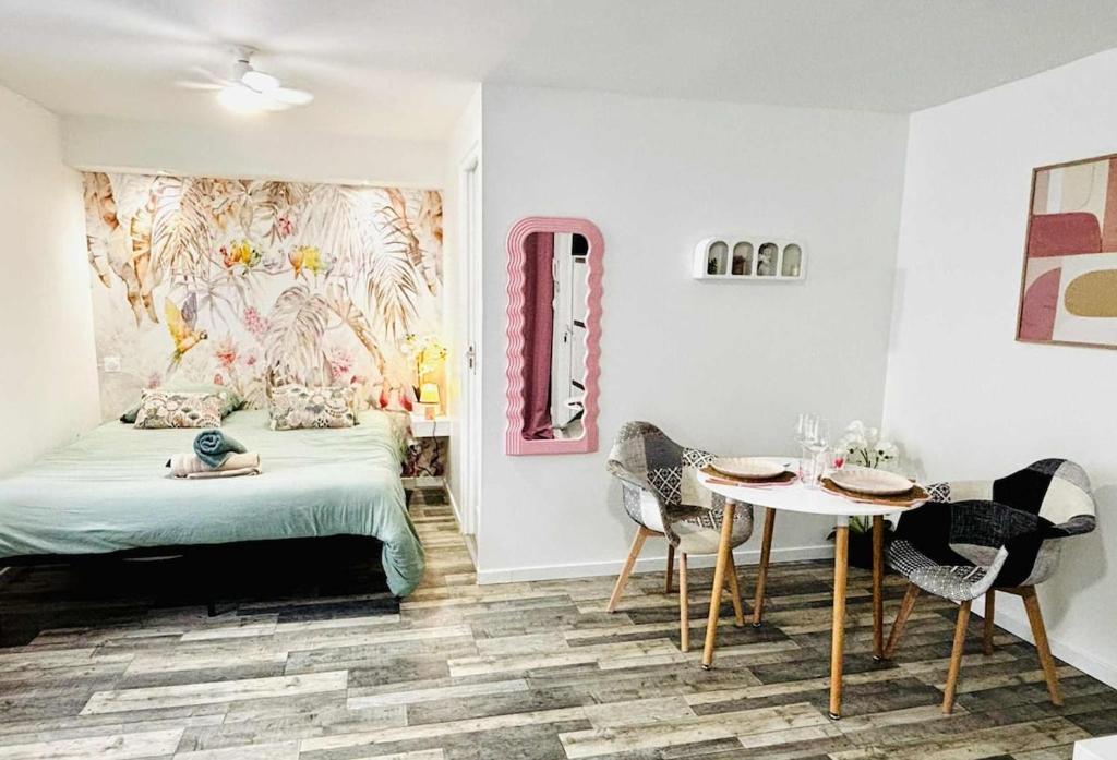 Un dormitorio con una cama y una mesa y sillas. en la bulle d'Edward gare jardin centre, en Angulema