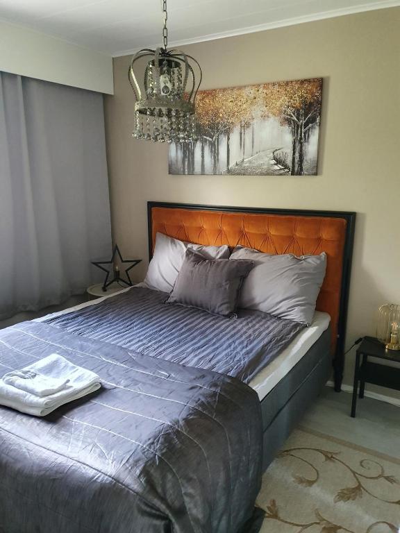 a bedroom with a bed with an orange head board at Luxury 1br apartment in Liminka