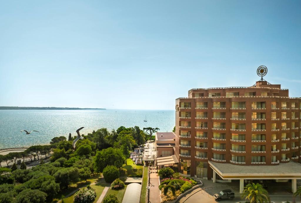 ポルトロスにあるRemisens Hotel METROPOLの大きな水域の隣にある大きな建物