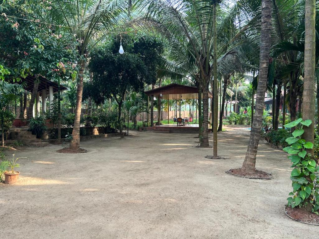 a park with palm trees and a gazebo at Savali farm stay in Parchuri