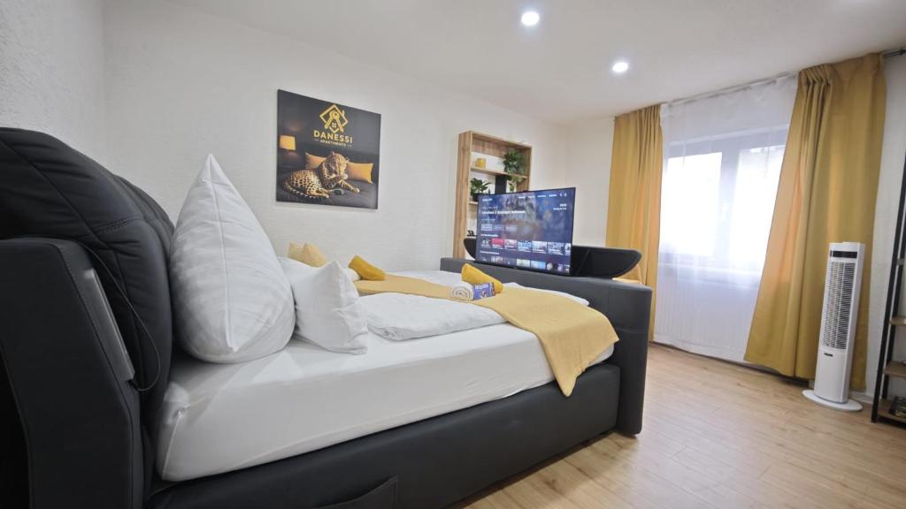 1 dormitorio con 1 cama y TV en DANESSI-Business-Apartment, nahe Industriegebiet und Koblenz, WLAN, Smart TV Boxspringbett mit Waipu, Vollausgestattete Küche uvm, en Mülheim-Kärlich
