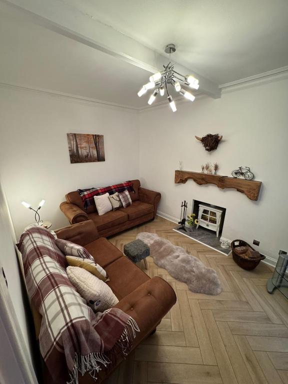 a living room with a couch and a fireplace at Glenburn Cottage in Kirkmichael
