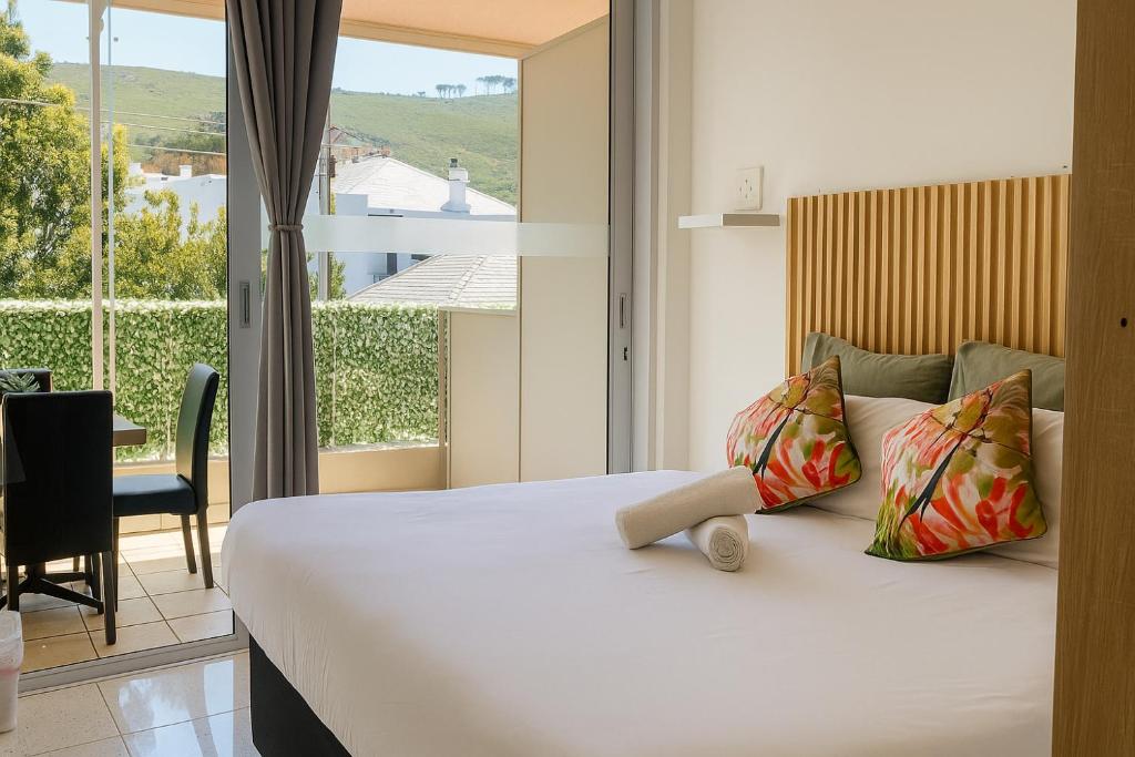 ケープタウンにあるSweetStay - Kloof Streetのベッドと大きな窓のある寝室