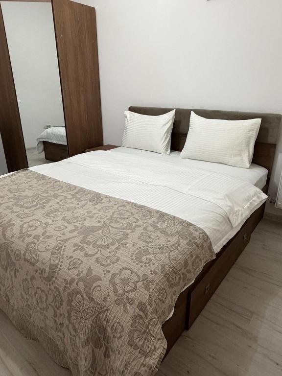 a bed with white sheets and pillows on it at Julia Militari Studio in Roşu